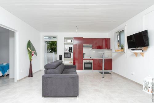 a living room with a couch and a kitchen at Villa belle lune in La Trinité