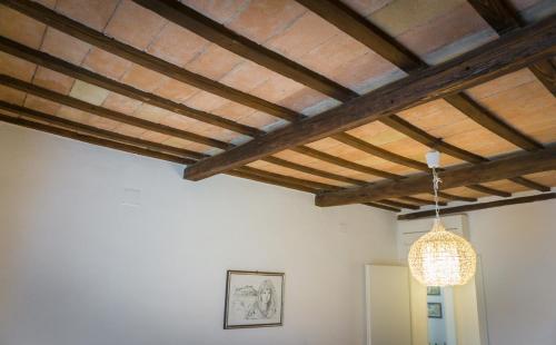 a ceiling with wooden beams and a light fixture at Appartamento Palma in Spello