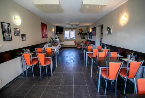 a dining room with tables and orange chairs at Penzion Vion in Plzeň