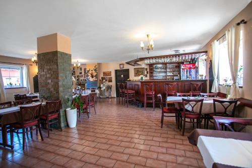 un restaurante con mesas y sillas y un bar en Penzion Vion, en Plzeň