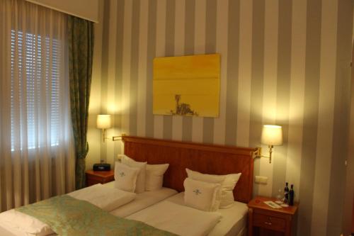 a bedroom with a bed with white sheets and pillows at Hotel Savoy Hannover in Hannover