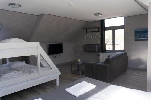 a bedroom with a bunk bed and a living room at Hotel Waddengenot in Pieterburen