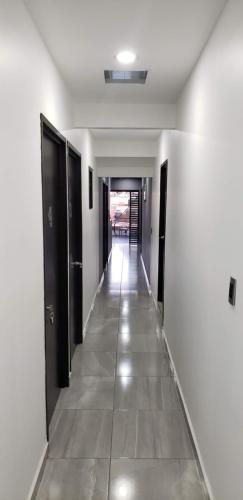 a hallway with black doors and a tile floor at El Suburbio - Morelos Sur in Morelia