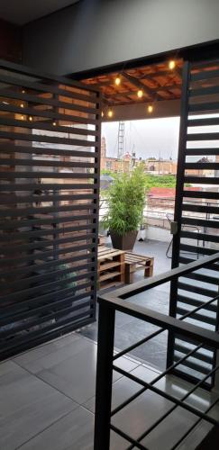 a balcony with wooden blinds and a table and bench at El Suburbio - Morelos Sur in Morelia
