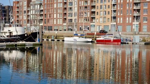 two boats are docked in a marina with buildings at Bizstay Harbour II Scheveningen Apartments in Scheveningen