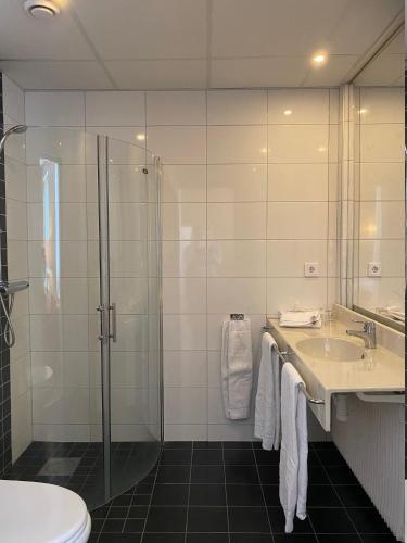a bathroom with a shower and a sink and a toilet at Strand City Hotel in Örnsköldsvik
