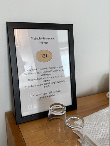a framed picture of a wine glass on a table at Strand City Hotel in Örnsköldsvik
