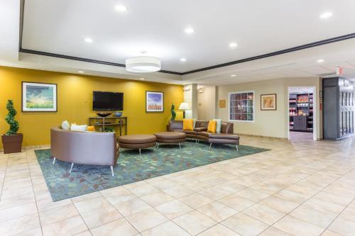a lobby with a waiting room with couches and a tv at Candlewood Suites Aurora-Naperville by IHG in Aurora
