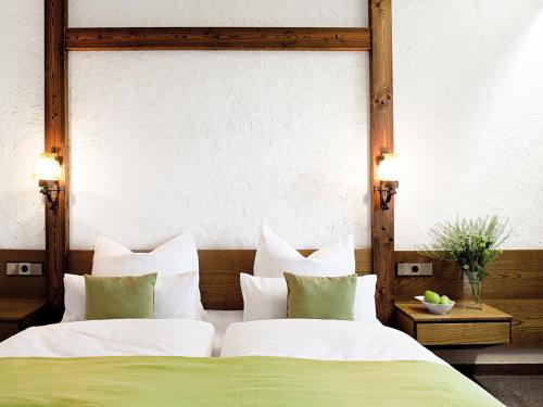 a bedroom with two beds with green and white pillows at Hotel-Landgasthof KREUZ in Bad Waldsee