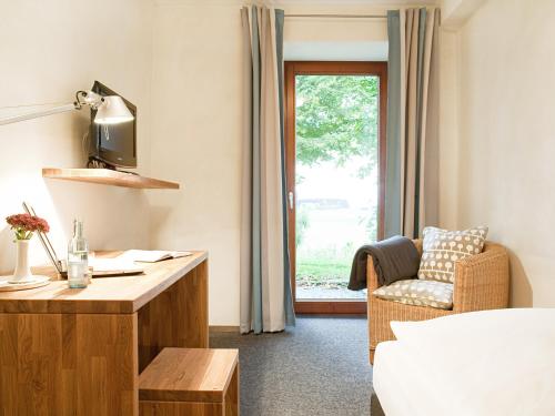 a room with a desk and a chair and a window at Hotel-Landgasthof KREUZ in Bad Waldsee