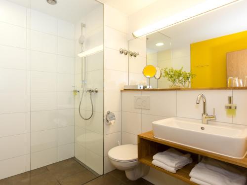 a bathroom with a sink and a toilet and a shower at Hotel-Landgasthof KREUZ in Bad Waldsee