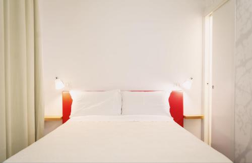 a bed with white sheets and pillows in a room at Giardino Sul Duomo in Ragusa