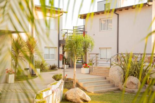 una casa con escaleras y plantas delante de ella en Good Life Resort en La Falda