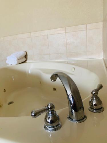a bath tub with a sink with a faucet at Country Inn & Suites by Radisson, Ithaca, NY in Ithaca