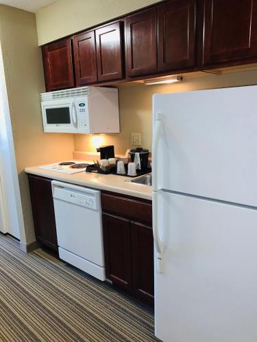 a kitchen with a white refrigerator and a microwave at Country Inn & Suites by Radisson, Ithaca, NY in Ithaca