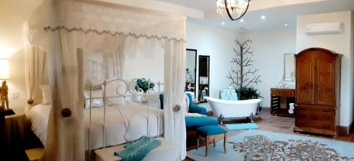 een slaapkamer met een bed en een bad in een kamer bij Hotel Hacienda Santana in Tecate