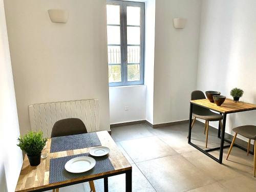 une salle à manger avec une table et des chaises et une fenêtre dans l'établissement Les Tourelles, à Biarritz