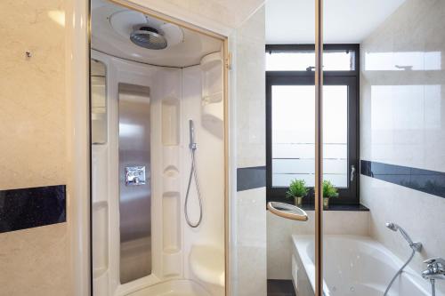 uma casa de banho com um chuveiro, uma banheira e um lavatório. em Hotel van der Valk Wolvega-Heerenveen em Wolvega