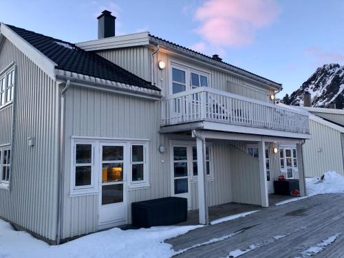 a house with a balcony and a deck at Rorbuene Svolvær Havn in Svolvær