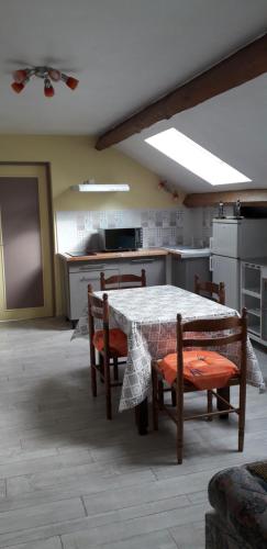 une cuisine avec une table et des chaises dans une cuisine dans l'établissement Gîte Les Chevaliers fous, à Sainte-Menehould