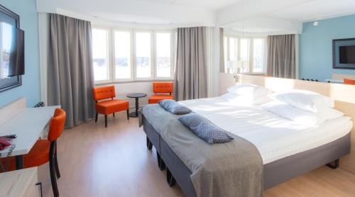 a bedroom with a large bed and a desk and chairs at Original Sokos Hotel Seurahuone Savonlinna in Savonlinna