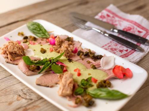 a plate of food with meat and vegetables on a table at Hotel-Landgasthof KREUZ in Bad Waldsee