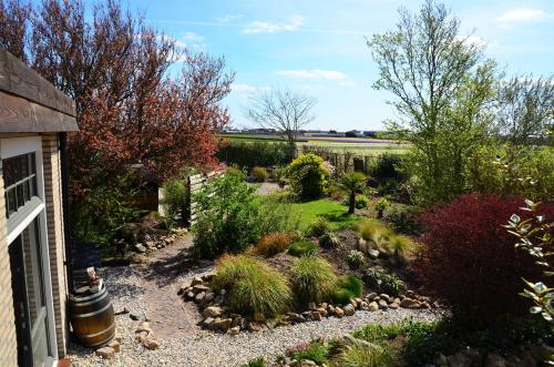 a garden with rocks and plants in front of a house at Wellness Bed & Breakfast Pergamo in Voorhout