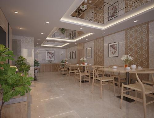 a restaurant with tables and chairs in a room at Fukurai Hotel & Apartment 2 Ha Noi in Hanoi
