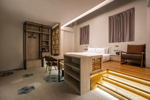 Schlafzimmer mit einem Bett, einem Schreibtisch und einem Tisch in der Unterkunft The Quay Hotel in Singapur