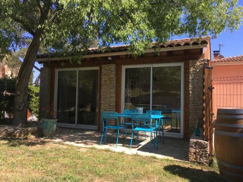 a patio with blue chairs and a table at La chambre haute, son jardin, et, son SPA in Nîmes