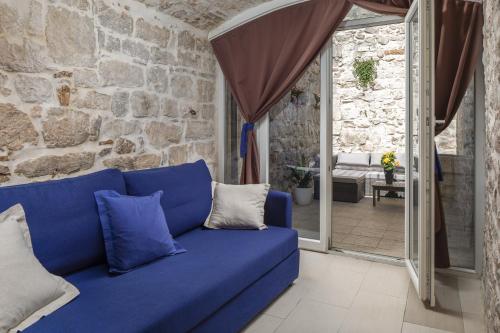 Sofá azul en una habitación con pared de piedra en Awesome Stone House, en Split