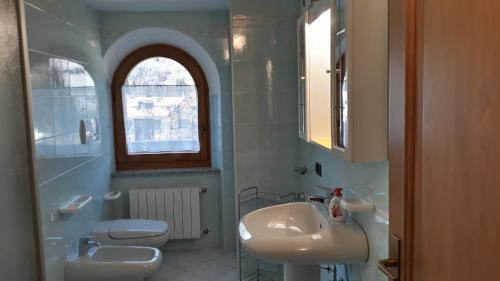 a white bathroom with a sink and a toilet at Casa Bamby in Cogolo