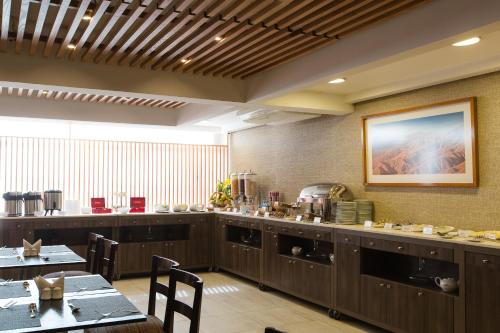 a restaurant with a table and chairs and a kitchen at Hotel Atacama Suites in Copiapó