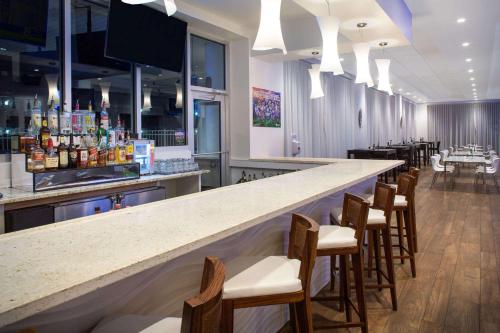 a bar in a restaurant with a row of stools at Ramada by Wyndham Venice Hotel Venezia in Venice