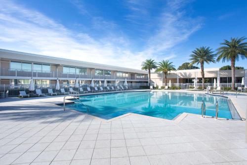 a swimming pool in a building with chairs and palm trees at Ramada by Wyndham Venice Hotel Venezia in Venice