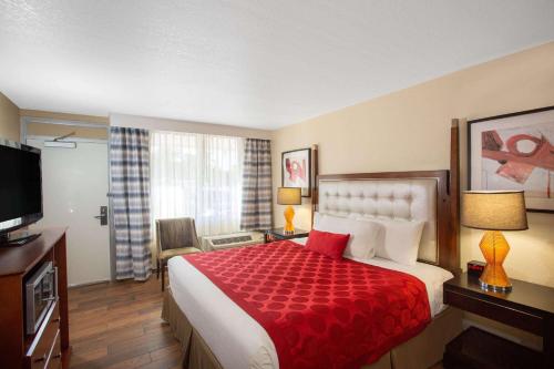 a hotel room with a bed with a red blanket at Ramada by Wyndham Venice Hotel Venezia in Venice