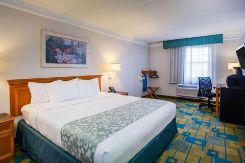 a hotel room with a large bed and a window at La Quinta Inn by Wyndham Norfolk Virginia Beach in Virginia Beach