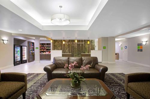a living room with a leather couch and a table at La Quinta by Wyndham Visalia/Sequoia Gateway in Visalia