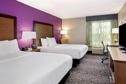 a hotel room with two beds and purple walls at La Quinta by Wyndham Visalia/Sequoia Gateway in Visalia
