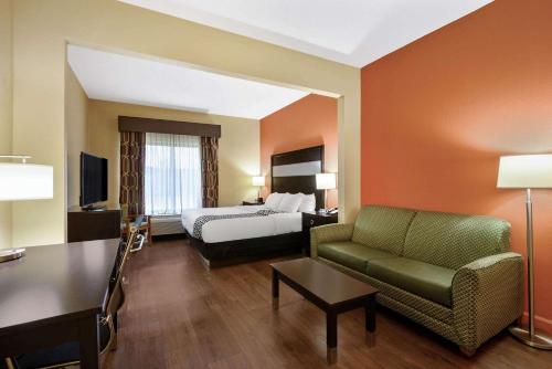 a hotel room with a bed and a couch at La Quinta by Wyndham Florence in Florence