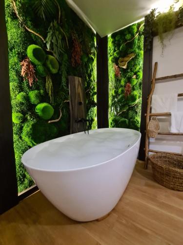 a bathroom with a green wall with a white bath tub at Rooms Apartments in Samara
