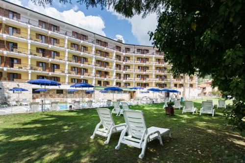 a group of chairs and umbrellas in front of a hotel at Grand Hotel del Parco in Pescasseroli