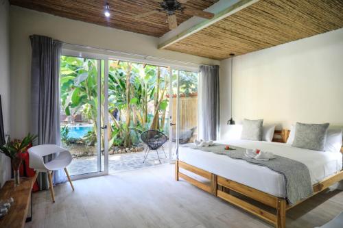 a bedroom with a bed and a large window at Manala Hotel in Santa Teresa Beach