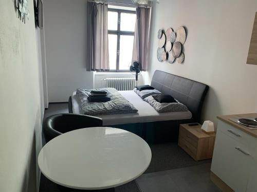 a small room with a bed and a white table at Penzion Měšťan in Jindrichuv Hradec