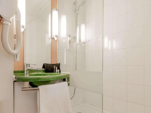 een badkamer met een groene wastafel en een douche bij ibis Lourdes Centre Gare in Lourdes