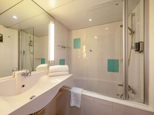 a bathroom with a shower and a sink and a tub at Novotel Nice Centre Vieux Nice in Nice