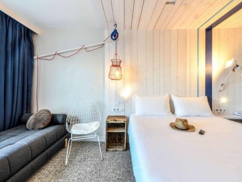 - une chambre avec un lit et un canapé dans l'établissement ibis styles La Rochelle Thalasso Chatelaillon, à Châtelaillon-Plage