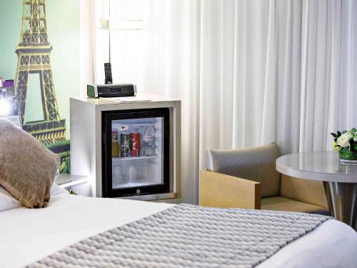 a hotel room with a bed and a table with a chair at Mercure Paris Vaugirard Porte De Versailles in Paris
