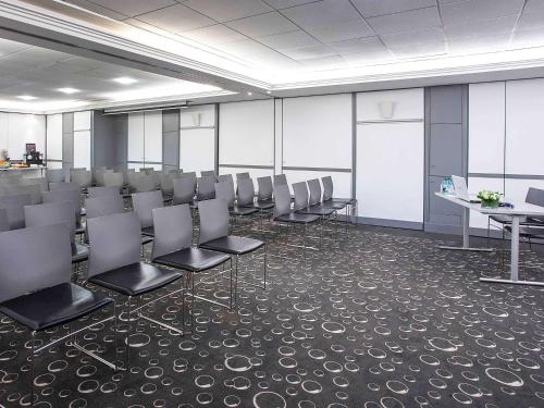 a conference room with chairs and a table and a podium at Mercure Paris Vaugirard Porte De Versailles in Paris