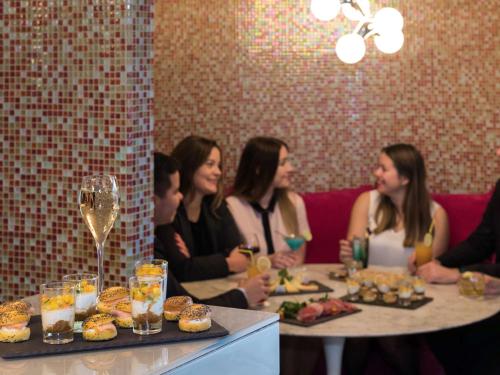 a group of people sitting at a table with food and drinks at Mercure Paris Vaugirard Porte De Versailles in Paris